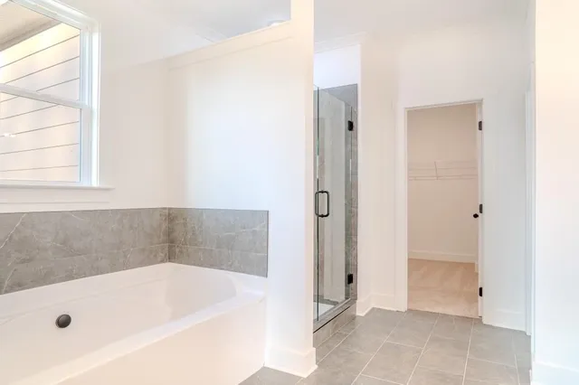 a bathroom with a tub a shower and a sink