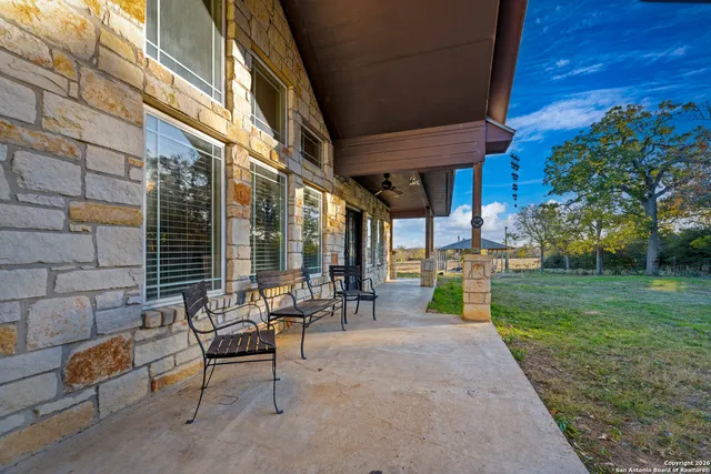 a view of a chairs and table in patio with a yard