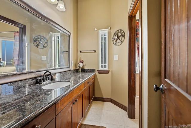 a bathroom with a granite countertop sink and a mirror