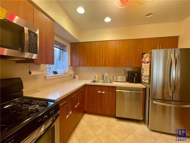 a kitchen with stainless steel appliances granite countertop a refrigerator and a stove top oven