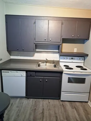 a kitchen with granite countertop a stove and a sink