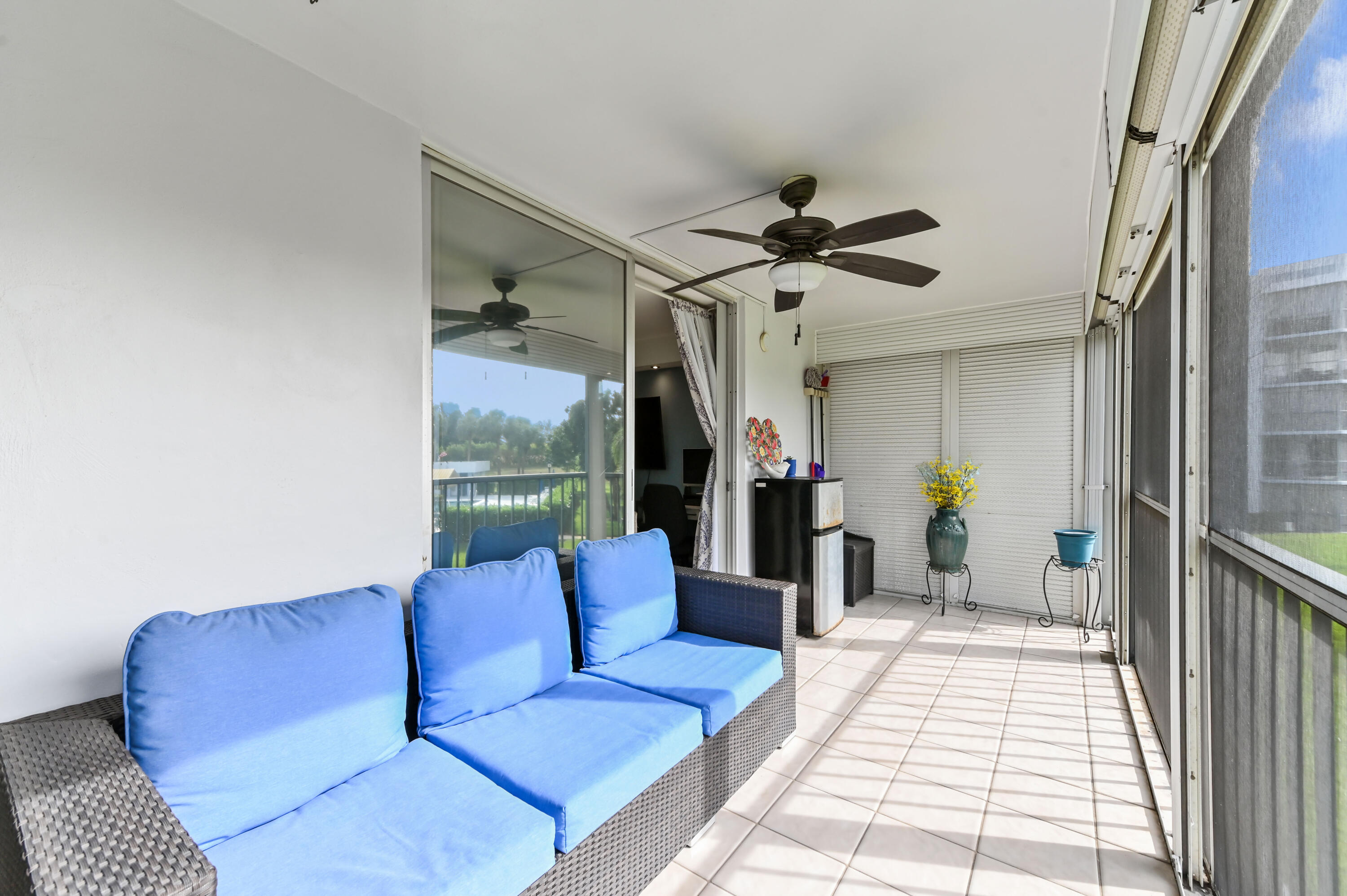 198 Northwest 67th Street, Unit 207 Boca Raton, FL 33487 - Photo 32 of 42 a living room with furniture ceiling fan and a rug