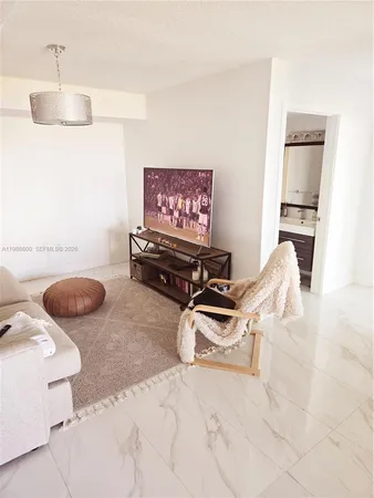 a living room with furniture a rug and a chandelier