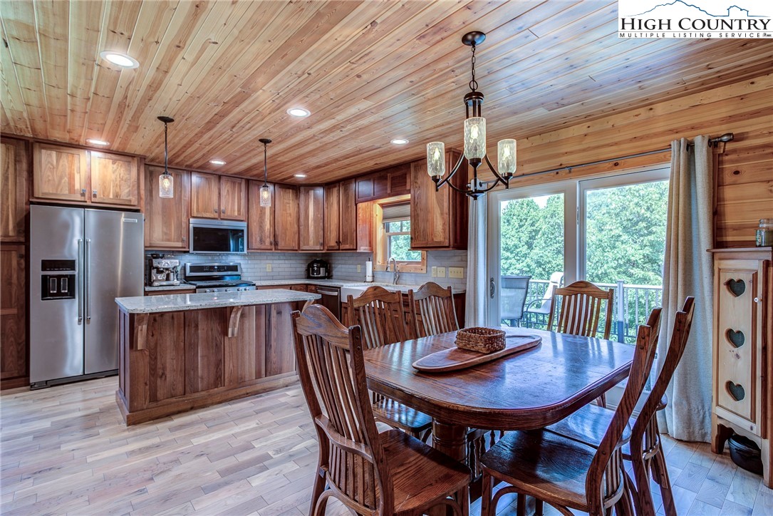 1210 Staghorn Road Purlear, NC 28665 - Photo 1 of 42 a kitchen with stainless steel appliances granite countertop a dining table chairs refrigerator and cabinets