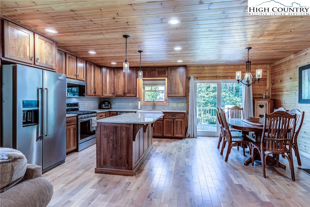 1210 Staghorn Road Purlear, NC 28665 - Photo 20 of 42 a kitchen with stainless steel appliances wooden floors wooden cabinets and wooden floors