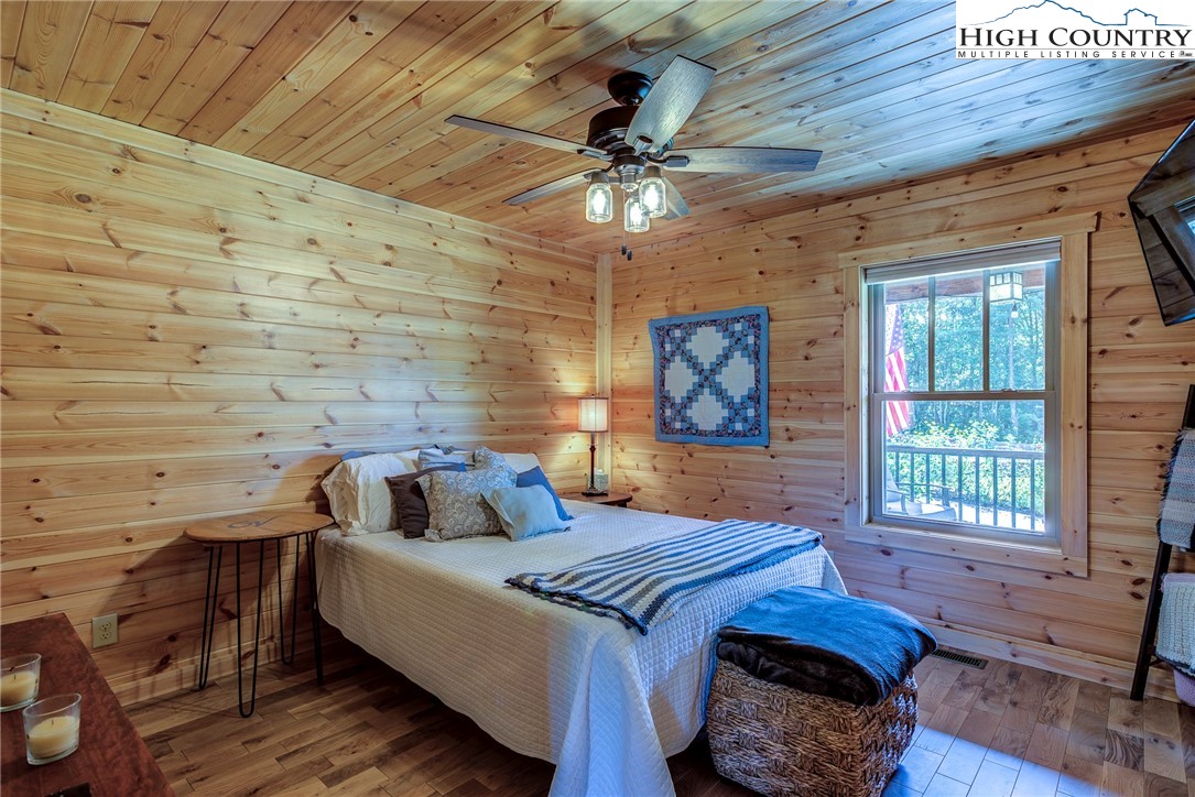 1210 Staghorn Road Purlear, NC 28665 - Photo 21 of 42 a bedroom with a bed and a chandelier