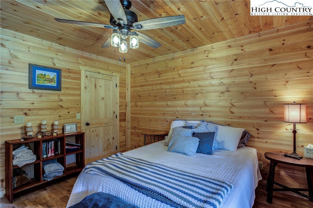 1210 Staghorn Road Purlear, NC 28665 - Photo 22 of 42 a bedroom with a bed and a chandelier