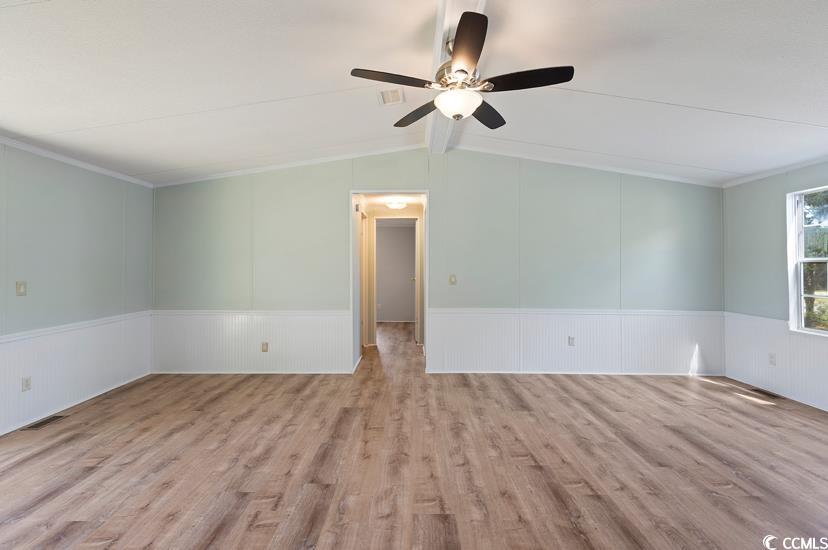 1030 Levi Street Manning, SC 29102 - Photo 12 of 31 Living room wood finished floors, ceiling fan, a wainscoted wall, and ornamental molding