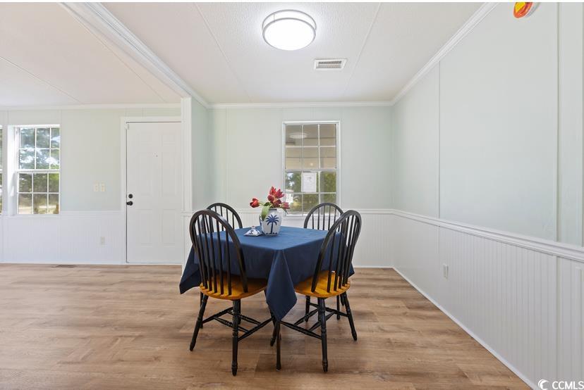 1030 Levi Street Manning, SC 29102 - Photo 13 of 31 Dining room featuring crown molding, wood finished floors, a wainscoted wall, and a decorative wall
