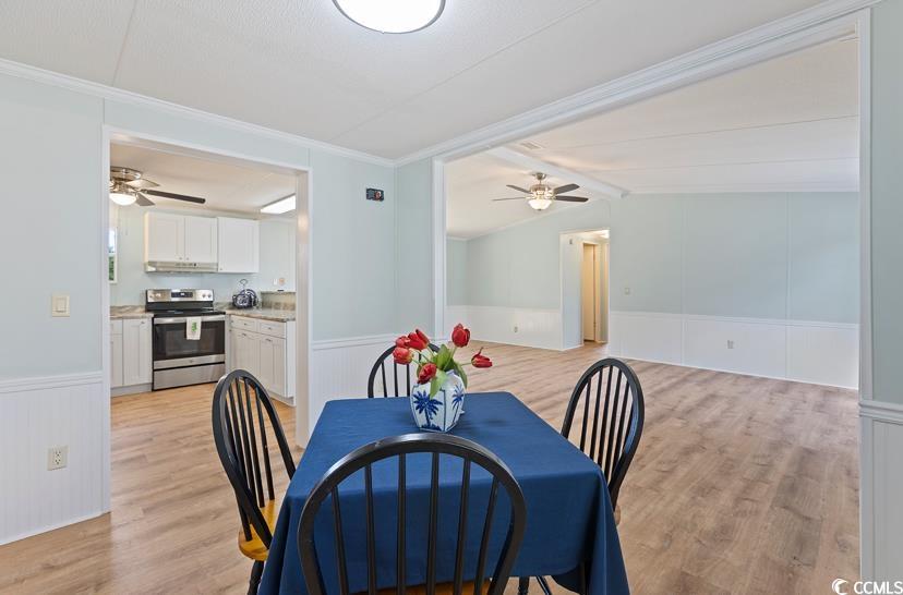 1030 Levi Street Manning, SC 29102 - Photo 14 of 31 Dining space featuring a ceiling fan, a wainscoted wall, light wood finished floors, crown molding, and vaulted ceiling