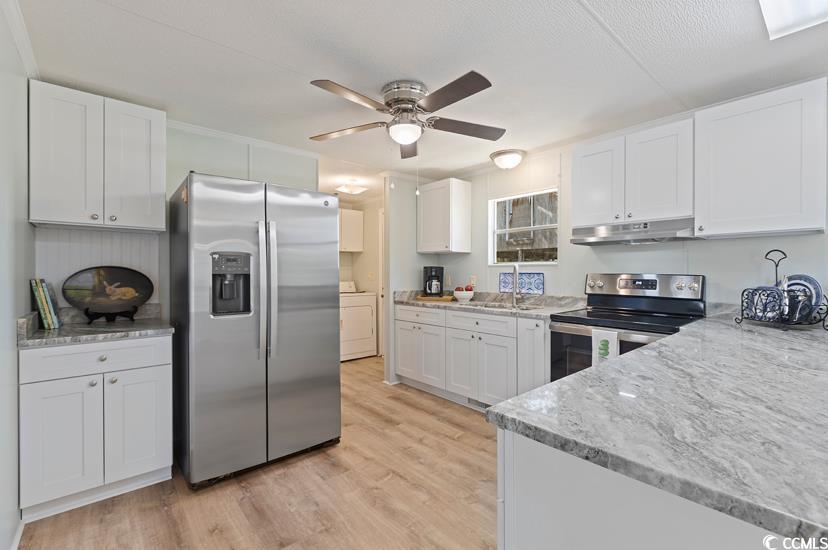 1030 Levi Street Manning, SC 29102 - Photo 17 of 31 Kitchen with appliances with stainless steel finishes, under cabinet range hood, washer / clothes dryer, ceiling fan, and white cabinetry