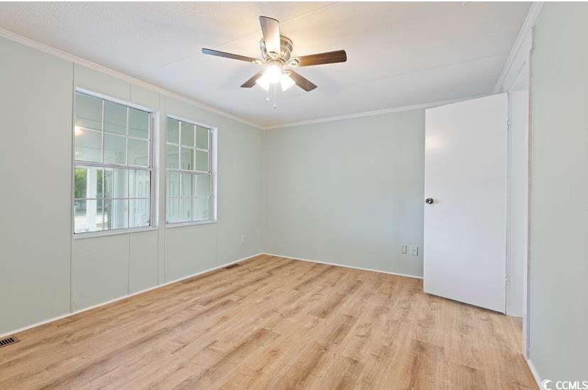 1030 Levi Street Manning, SC 29102 - Photo 20 of 31 Spare room with ornamental molding, light wood-style floors, and ceiling fan
