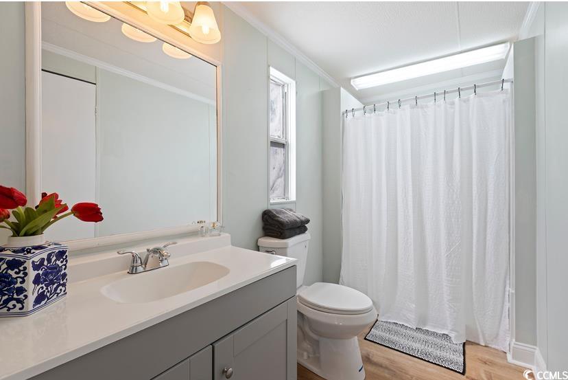 1030 Levi Street Manning, SC 29102 - Photo 22 of 31 Full bath with vanity, toilet, wood finished floors, ornamental molding, and curtained shower