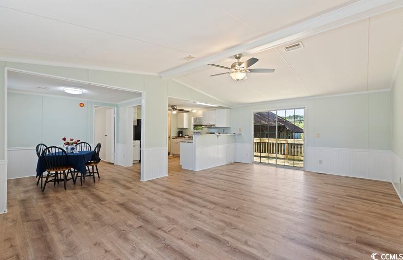 1030 Levi Street Manning, SC 29102 - Photo 8 of 31 Living room with ceiling fan, light wood finished floors, a wainscoted wall, and a decorative wall