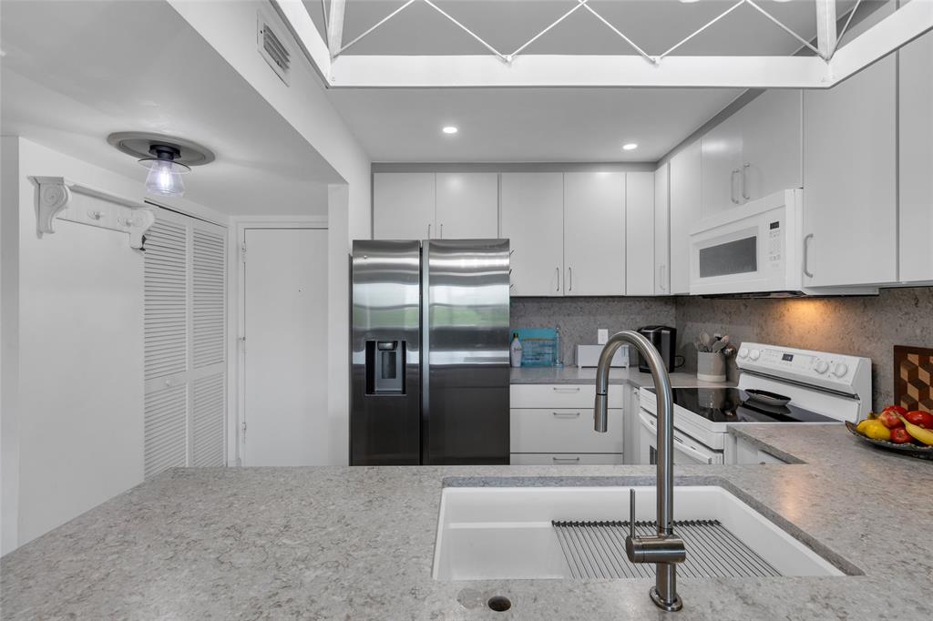 900 River Reach Drive, Unit 518 Fort Lauderdale, FL 33315 - Photo 9 of 47 a kitchen with stainless steel appliances granite countertop a refrigerator and a sink