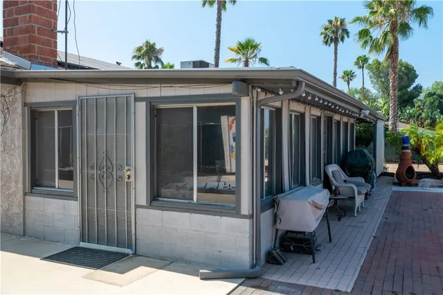 a view of a patio with table and chairs potted plants and palm tree