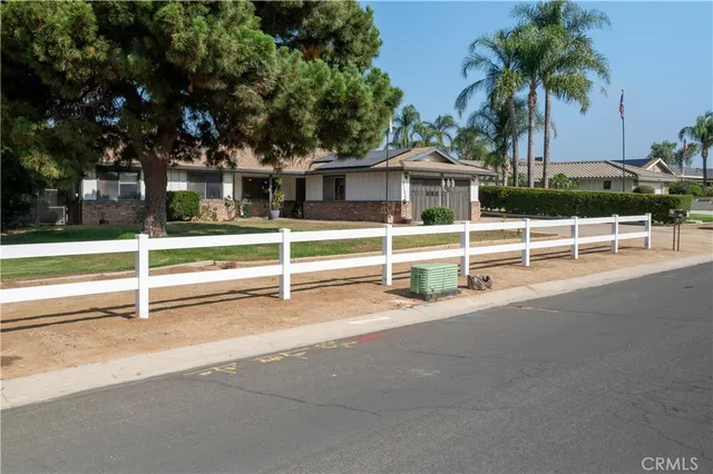 a view of a house with a yard and palm trees