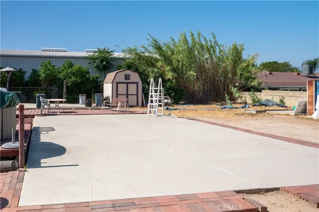 a view of a patio with a table and chairs under an umbrella