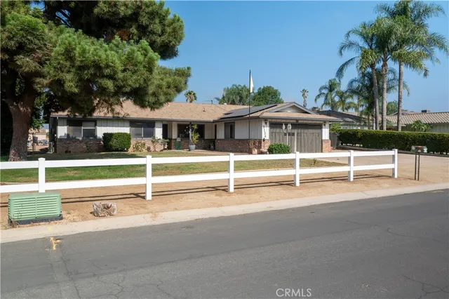 a view of a house with a yard and potted plants