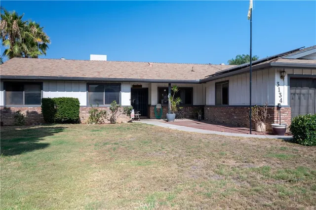 front view of a brick house with potted plants