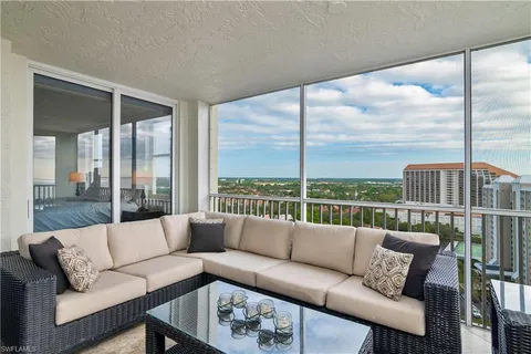 a living room with furniture view and large windows