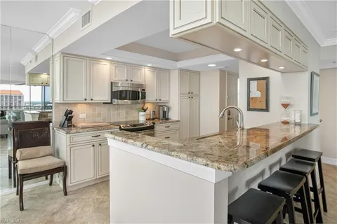 a kitchen with kitchen island granite countertop a stove a sink and a refrigerator