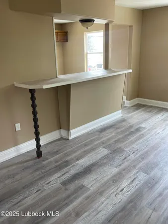 a room with wooden floor and windows