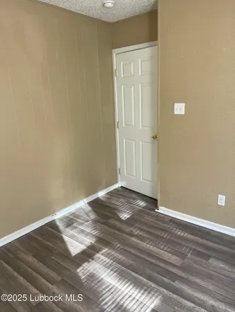 a view of a small space with wooden floor and a window