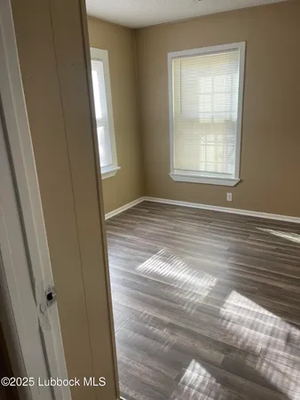 a view of an empty room with wooden floor
