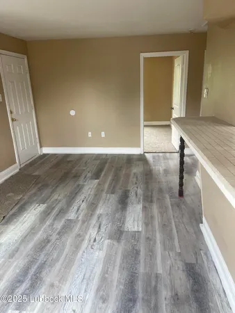 a view of a livingroom with wooden floor and staircase