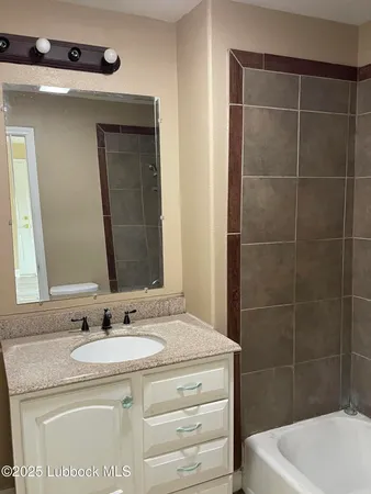 a bathroom with a granite countertop sink a toilet and bathtub