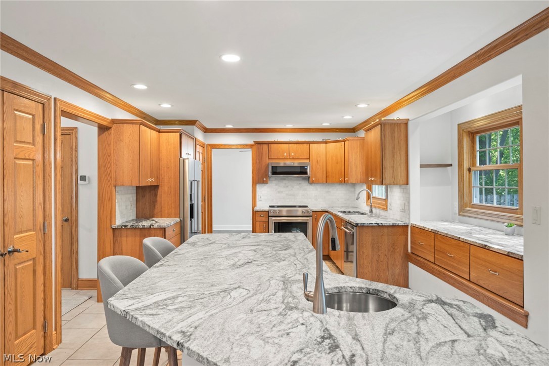 3871 Greentree Road Stow, OH 44224 - Photo 13 of 50 Kitchen featuring an expansive island with an undermount sink, light wood cabinetry, and stainless steel appliances