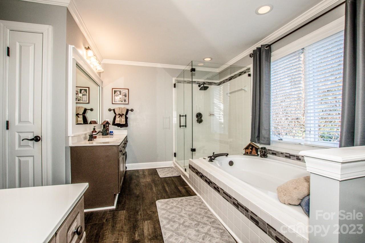 17506 Springwinds Drive Cornelius, NC 28031 - Photo 18 of 35 a bathroom with a tub a sink and a large mirror