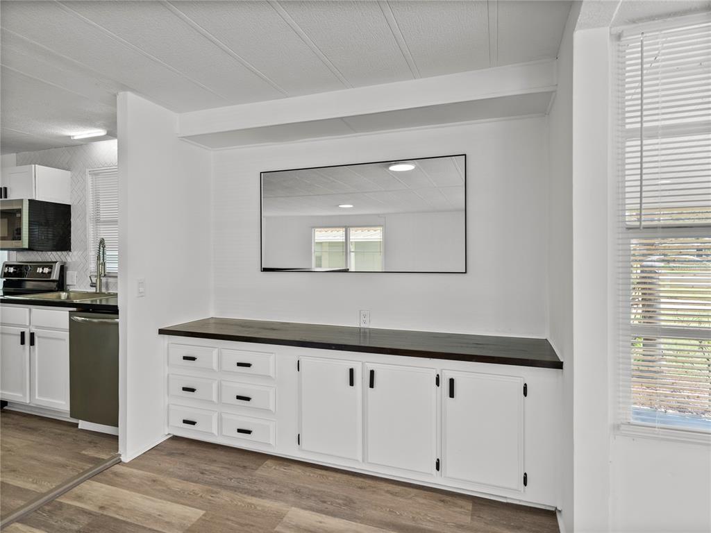 1610 Reynolds Road, Unit 35 Lakeland, FL 33801 - Photo 12 of 59 a kitchen with white cabinets and a wooden floor