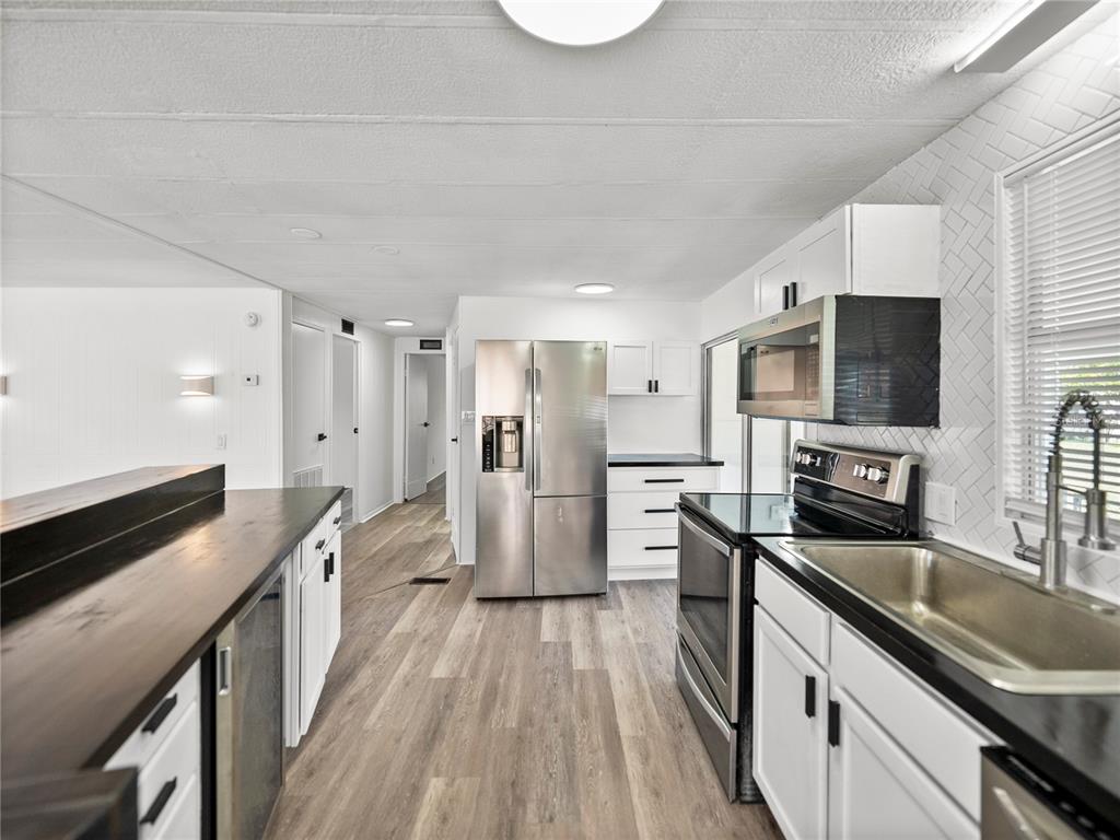 1610 Reynolds Road, Unit 35 Lakeland, FL 33801 - Photo 15 of 59 a kitchen with stainless steel appliances a stove sink microwave and cabinets