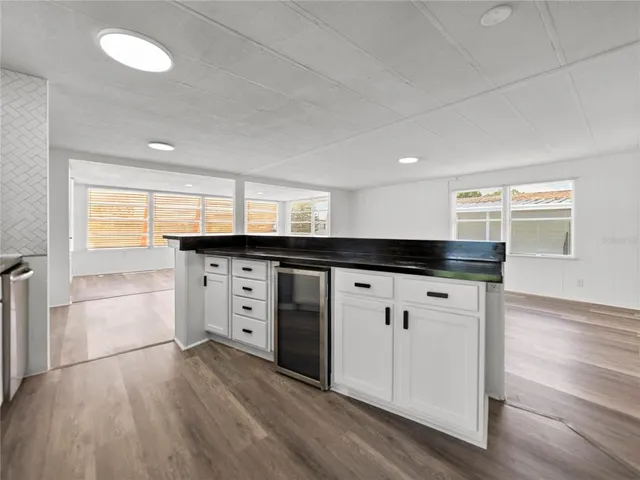 a kitchen with granite countertop a refrigerator and a stove top oven