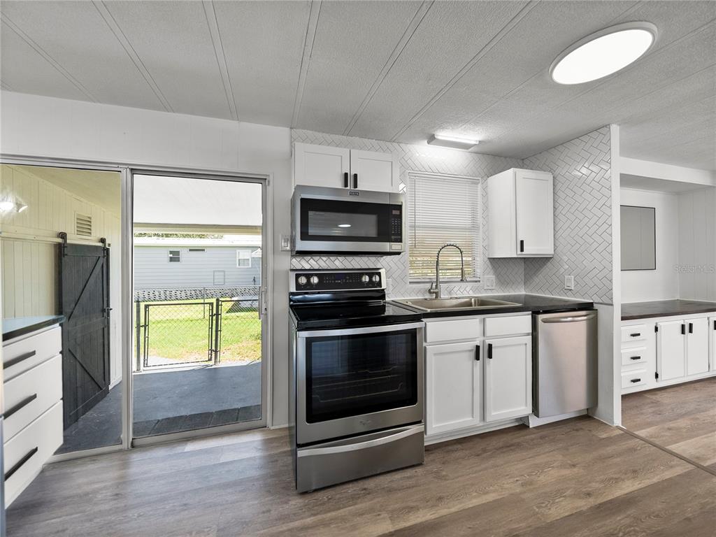 1610 Reynolds Road, Unit 35 Lakeland, FL 33801 - Photo 19 of 59 a kitchen with granite countertop a refrigerator and a stove top oven