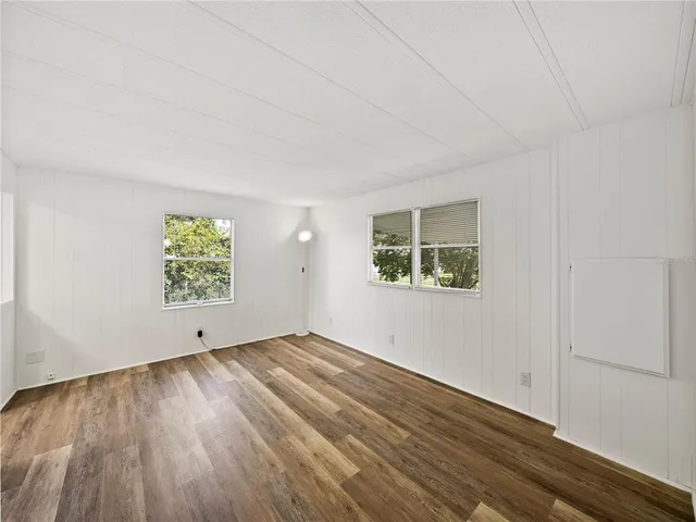 a view of empty room with wooden floor