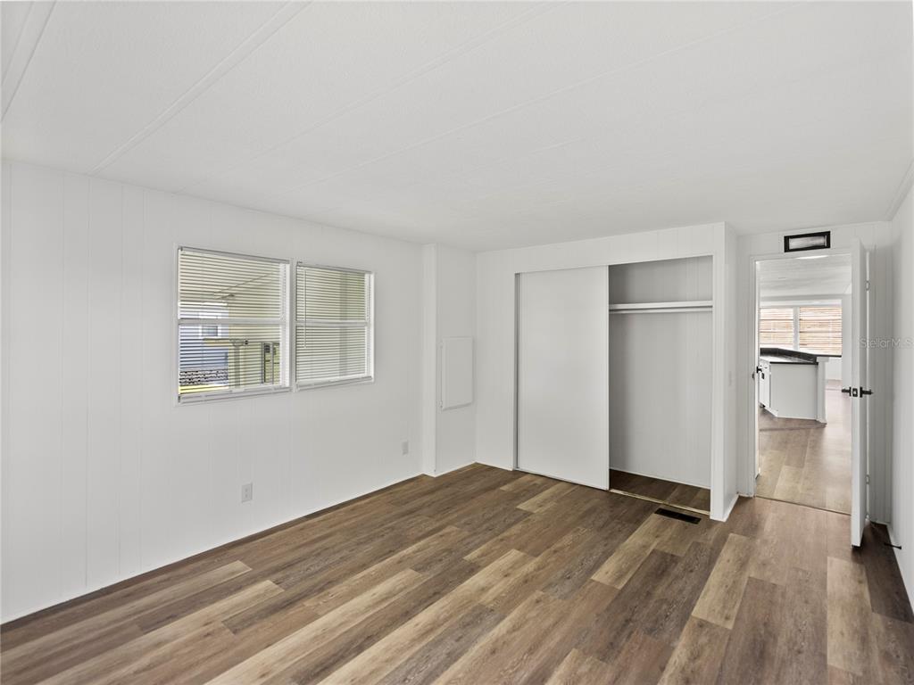 1610 Reynolds Road, Unit 35 Lakeland, FL 33801 - Photo 30 of 59 a view of empty room with wooden floor and kitchen