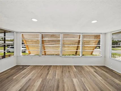 a view of an empty room with a fireplace and a window