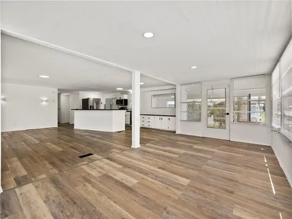 a view of a kitchen with wooden floor and a window
