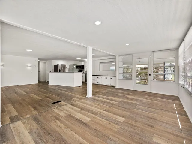 a view of a kitchen with wooden floor and a window