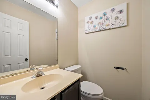 a bathroom with a toilet a sink and mirror
