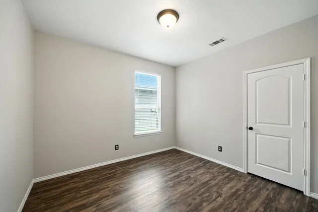 a view of a room with wooden floor and window