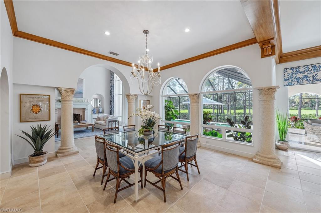837 Barcarmil Way Naples, FL 34110 - Photo 13 of 38 a view of a dining room with furniture a chandelier and large windows