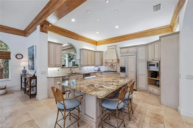 a kitchen with stainless steel appliances kitchen island granite countertop a table and chairs in it