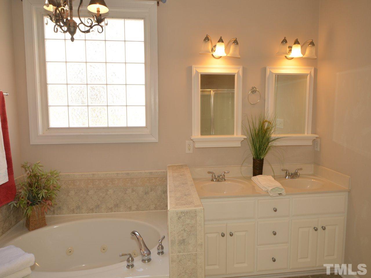 812 Nowell Ridge Road Raleigh, NC 27607 - Photo 9 of 21 a bathroom with a bathtub a sink and a window
