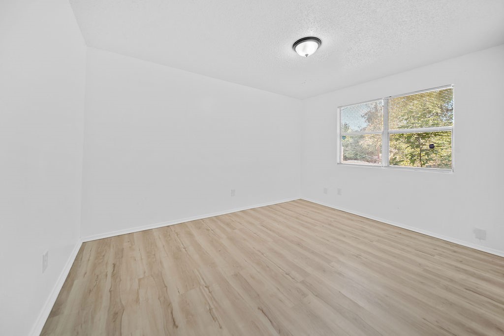 3058 Old Colony Road Huntsville, TX 77320 - Photo 21 of 25 a view of an empty room with wooden floor and a window