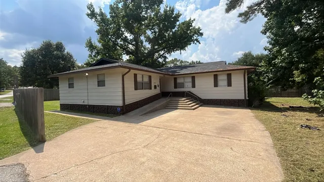 a backyard of a house with large trees and barbeque oven