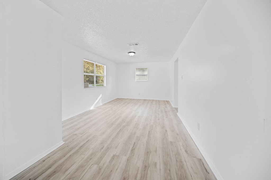 3058 Old Colony Road Huntsville, TX 77320 - Photo 8 of 25 an empty room with wooden floor and windows